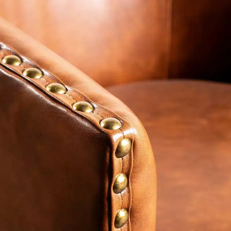 Poltrona Myles stile club commerciale con base girevole in metallo a 360° e rivestimento con borchie decorative