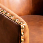 Poltrona Myles stile club commerciale con base girevole in metallo a 360° e rivestimento con borchie decorative